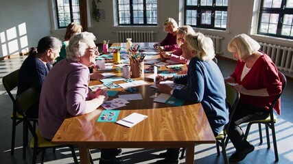 Group of seniors engaged in creative art activities indoors during daylight hours