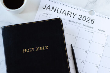 Christian holy bible book with January 2026 calendar and coffee cup. Studying, patience, annual...