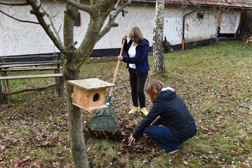 Women raking autumn leaves