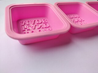 Close-up of bright pink, empty silicone molds designed for making artisanal soap bars.