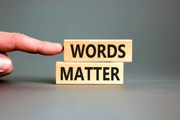 Words matter symbol. Concept word Words matter on beautiful wooden blocks. Beautiful grey paper background. Businessman's hand. Business words matter concept. Copy space.
