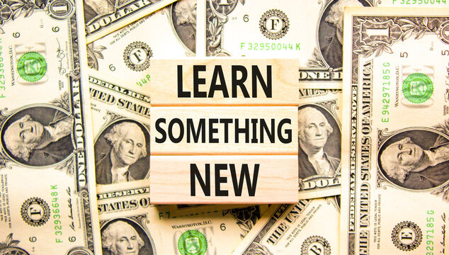 Learn something new symbol. Concept words Learn something new on beautiful wooden blocks. Beautiful background from dollar bills. Business motivational lifestyle learn something new concept Copy space