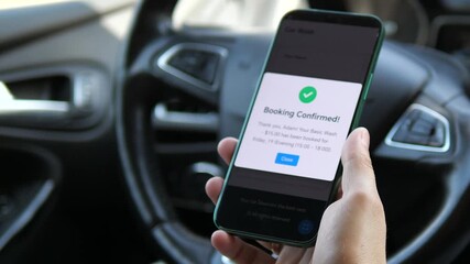 A driver reviews his scheduled car wash appointment in slow motion, showcasing how mobile technology helps manage vehicle maintenance. The clear confirmation screen represents effective personal