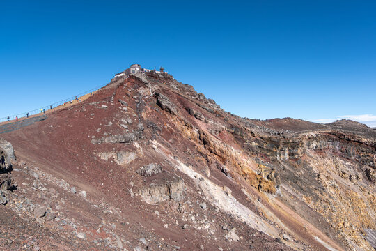 On Mount Fuji, Kitayama, Fujinomiya, Shizuoka, Japan, Hikers climbing rocky mountain trail under clear blue sky - Powered by Adobe