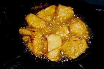 The process of frying tofu submerged in boiling oil