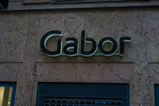 Vienna, Austria, Europe - Nov 08, 2025: gabor shoe store sign with raised black letters against a textured stone building facade above a dark closed security shutter