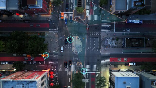 Aerial top down view of a city intersection with a digital overlay. Autonomous cars identified and tracked, showing data connection lines