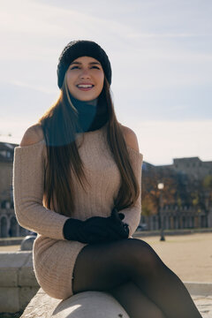 Mujer joven con sonrisa natural y alegre en una ma&ntilde;ana soleada de invierno en una plaza europea.
