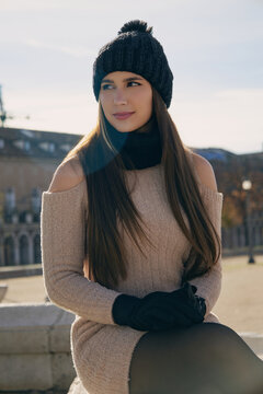 Mujer joven con sonrisa natural y alegre en una ma&ntilde;ana soleada de invierno en una plaza europea.