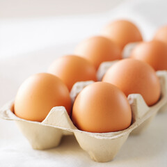 Egg Cartons Delight: A neat row of fresh brown eggs nestled in their cardboard home, ready for breakfast.