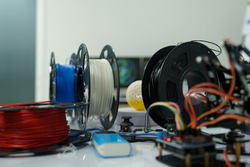 A 3D printer's cable reel prints a clear white plastic model using cutting-edge technology, focusing on a specific point, in the lab.