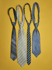 A set of mens ties on a yellow background