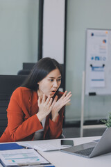 Asian business woman working on a laptop in a professional office