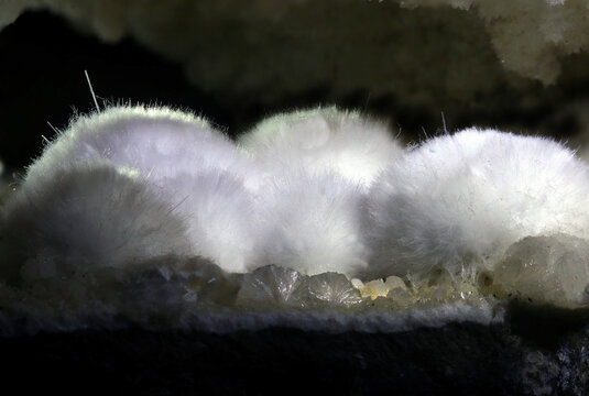 Okenit auf Muttergestein vor schwarzem Hintergrund