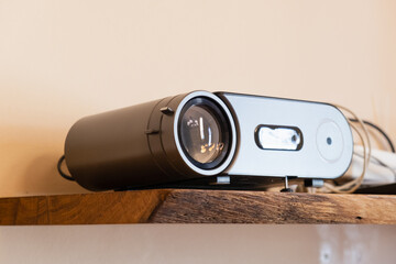 Modern home projector on wooden shelf