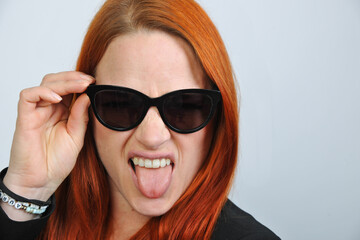 Naklejka premium rote, haare, rothaarig, ginger, zunge, rausstecken, frech, sonnenbrille, schönheit, glas, haar, leute, gesicht, gestalten, frau, person, leitbild, lächeln, glamour, brünett, blond, atelier, lippen, he