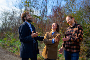 Friends laughing together on a sunny fall day in the woods during a casual outdoor gathering