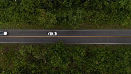 Aerial video of a rural road near a mountain with morning mist in Thailand.	