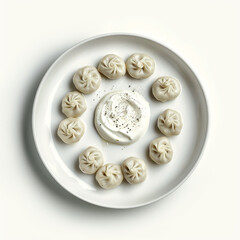A topdown view of a white plate featuring ten perfectly pleated dumplings arranged in a circle around a dollop of creamy white dipping sauce, isolated on white background
