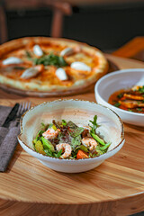 Shrimp Salad with Gourmet Pizza and Fish Dish on a Table