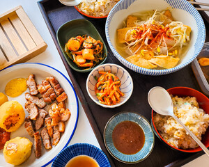 Warm Korean home-cooked meal with rice, tofu soup, kimchi, and assorted side dishes.