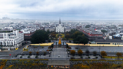 Drone view of Jackson Square and St. Louis Cathedral in New Orleans with a Christmas tree on a misty morning.