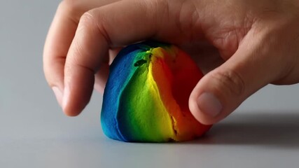 Person manipulating colorful thinking putty that changes hues with warmth showcasing innovative thermochromatic ink embedded in tactile materials.