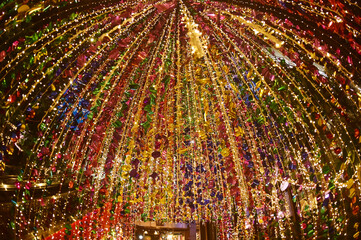 Texture and background of Plastic hanging with strings, illuminated with colored lights, sparkling and beautiful for Christmas day decorations.