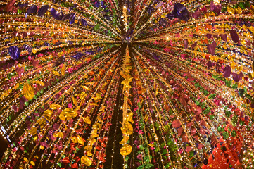 Texture and background of Plastic hanging with strings, illuminated with colored lights, sparkling and beautiful for Christmas day decorations.