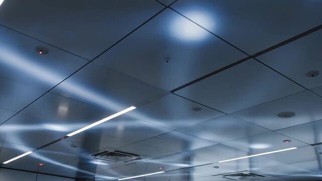 Modern ceiling with tiled panels and illuminated light fixtures