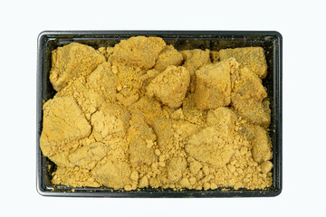 A tray of soft and jelly-like warabi mochi coated generously with golden kinako.The warabi mochi pieces have a tender, slightly translucent texture underneath the powder on the black plastic container