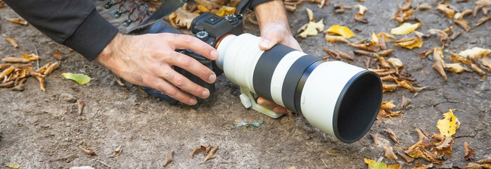 Photographer holding a digital camera taking pictures in nature.