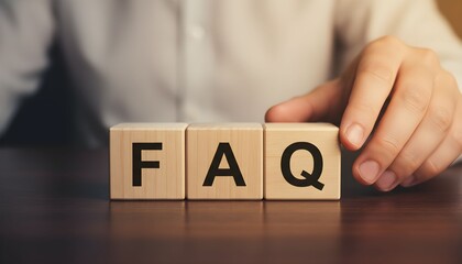 Naklejka premium Hand arranging wooden blocks spelling FAQ on a table.