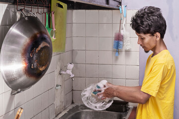 Man is washing a plate in a kitchen sink. Cleaning concept
