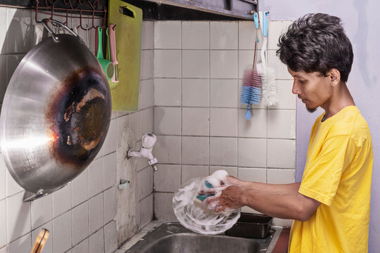 Man is washing a plate in a kitchen sink. Cleaning concept