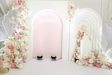 Full baby celebration backdrop with arches, floral installations, wings, and cake zone. Concept: premium, airy event design. Ideal for planners, venues, decorators, branding, and promotional materials