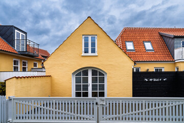 Charming Yellow Cottages With Red Tile Roofs And White Fences On A Quiet Street, Skagen Denmark