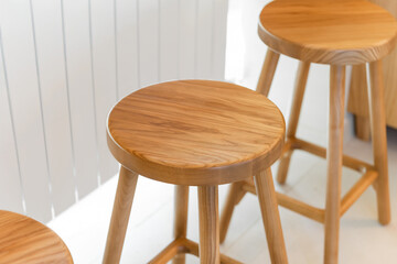 Wooden bar stools - high-key shot. Round wooden seats of three natural wood counter stools. Rich grain and smooth satin texture of the light-colored wood - clean, minimalist, Scandinavian aesthetic.