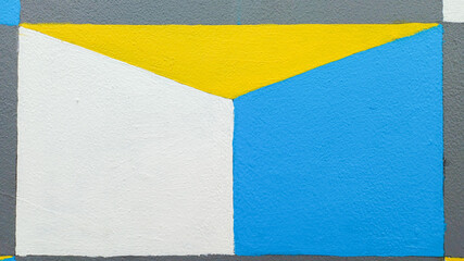 Abstract geometric color block pattern on a wall surface. Modern art background featuring squares and triangles in gray, white, bright blue, and yellow. Illusion of depth and structural design element