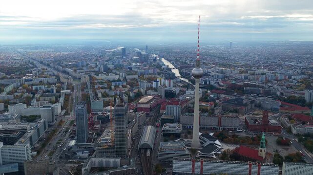 Aerial establishing shot of downtown Berlin featuring famous Fernsehturm television tower in Alexanderplatz and urban skyline on a cloudy day