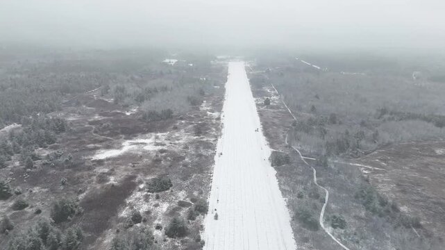 Approaching a snow-covered abandoned airport runway in winter. Former Cold War airstrip for interceptors. Remote Ontario wilderness