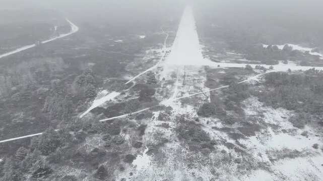 Slow motion circling the edge of the snowy, empty runway at the abandoned, closed, decommissioned Killaloe/Bonnechere Airport in Ontario, Canada, during a heavy winter snowfall