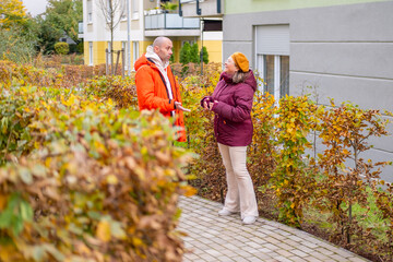 Real-life couple in warm autumn jackets arguing on autumn city street, emotional conversation, relationship tension, misunderstanding, conflict, communication issues, Man and woman walking outdoors