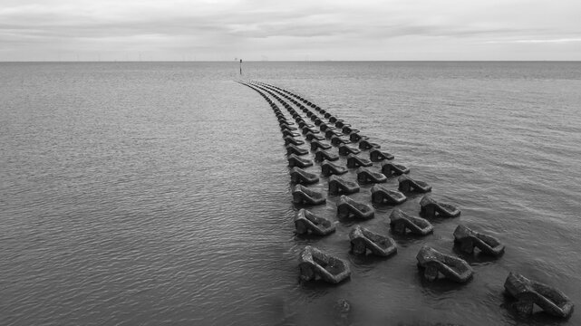 Aerial monotone view of concrete breakwater blocks 