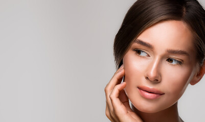 Beautiful young woman with perfect, clear skin, looking to the side. Skincare, hydration concept, with copy space.