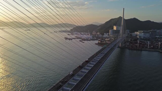 Aerial tilt view of Stonecutters Bridge crossing the bay at sunset in Hong Kong, 4k