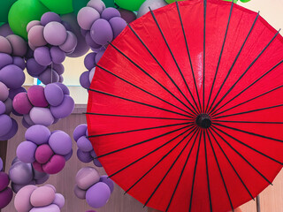 赤い日本の番傘とブドウ房のような紫のバルーンアートの和モダン装飾背景