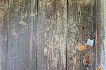 Weathered, old wooden door with traditional lock mechanism in a Central European village setting Closed, rusty lock, natural diffused lighting, quiet stillness
