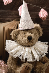 Portrait of vintage style teddy bear in lace ruff collar and a cap in sepia color