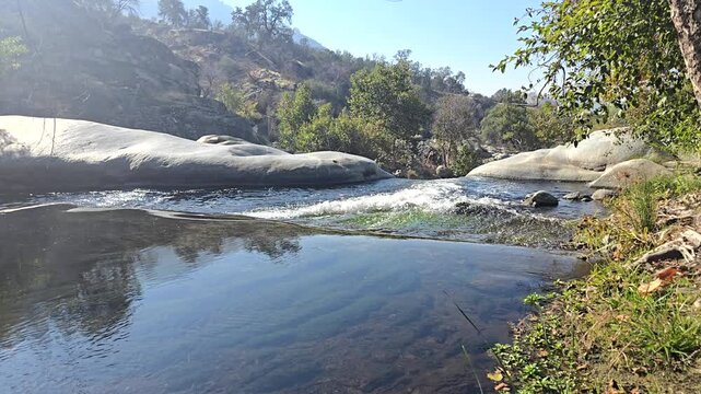 Serene river flowing through rocky Tule River landscape with trees.